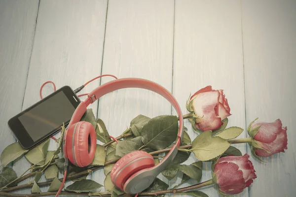 Romantischer Hintergrund mit roten Rosen auf Holztisch. — Stockfoto