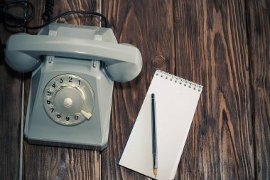 Klasik gri telefon, tahta arka planda yazı tahtası yakın plan, üst görünüm.