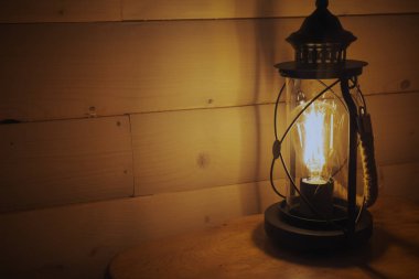 Ahşap bir duvarda asılı eski fener