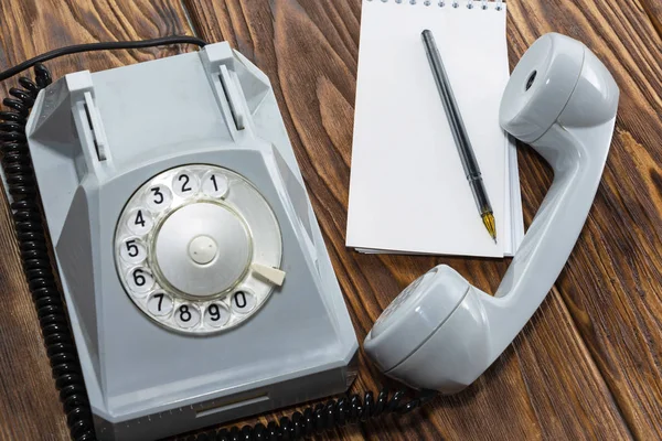 Klasik gri telefon, tahta arka planda yazı tahtası yakın plan, üst görünüm.