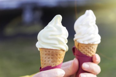 Kadının holding eritme dondurma waffle koni yaz ışık arka plan üzerinde elinde eller