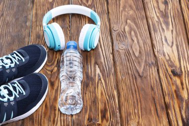 Spor malzemeleri. Spor ayakkabı, su, ahşap zemin üzerinde kulaklık