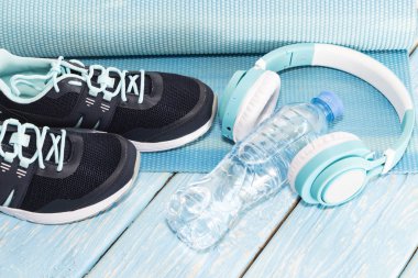 Yoga Mat, spor ayakkabı, su şişesi üzerinde mavi arka plan kavramı sağlıklı yaşam, sağlıklı beslenme, spor ve diyet