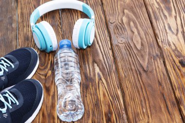 Spor malzemeleri. Spor ayakkabı, su, ahşap zemin üzerinde kulaklık