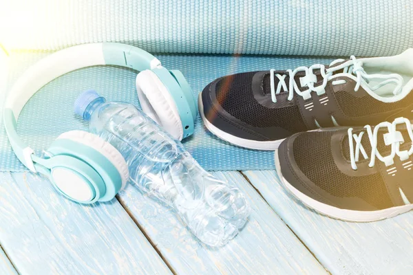 Yoga Mat, sports shoes, water bottle on blue background concept of healthy living, healthy eating, sports and diet