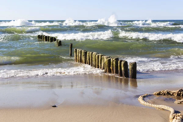 Una hermosa ola golpea la playa en una playa de arena en un día soleado. —  Fotos de Stock