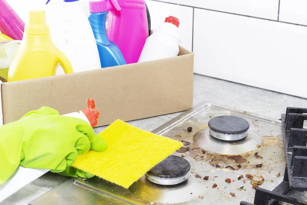 Limpeza de um fogão a gás com utensílios de cozinha, conceitos domésticos, ou higiene e limpeza. — Fotografia de Stock