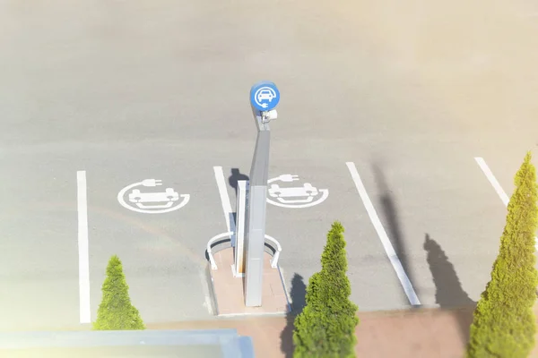 Elektrikli araçlar için şarj sembolü ile şehirde Park alanı.