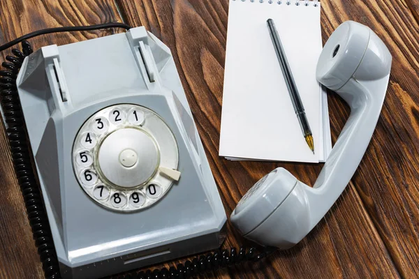 Klasik gri telefon, tahta arka planda yazı tahtası yakın plan, üst görünüm.
