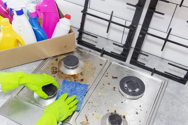 Limpeza de um fogão a gás com utensílios de cozinha, conceitos domésticos, ou higiene e limpeza. — Fotografia de Stock