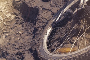 Bisiklet tekerleği çamura saplanmış. Kapat.