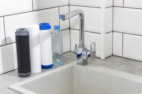 Water filter cartridge in the kitchen. Drinking water filtration system in the kitchen. Clean water at home.