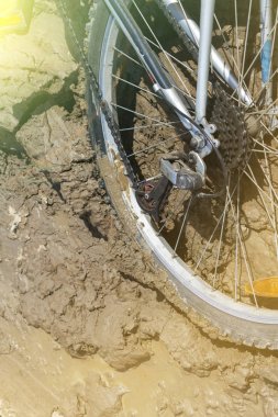 Bisiklet tekerleği çamura saplanmış. Kapat.
