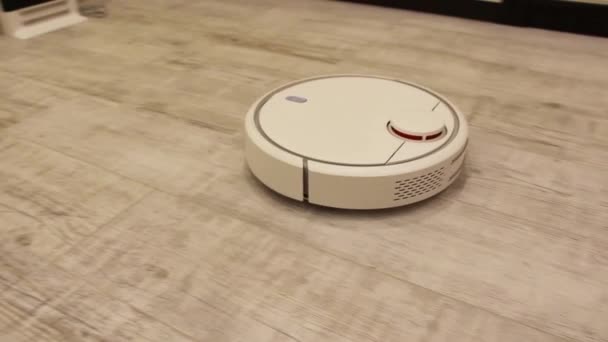Robot aspiradora realiza la limpieza automática del apartamento . — Vídeos de Stock