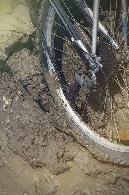 Bisiklet tekerleği çamura saplanmış. Kapat.
