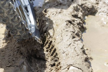 Bisiklet tekerleği çamura saplanmış. Kapat.