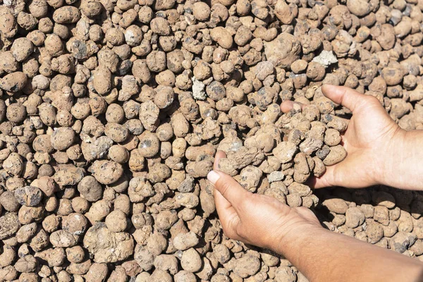 Construction of expanded clay, expanded clay in the hand of the worker. — Stock Image Construction of expanded clay, expanded clay in the hand of the worker. Stock Photo