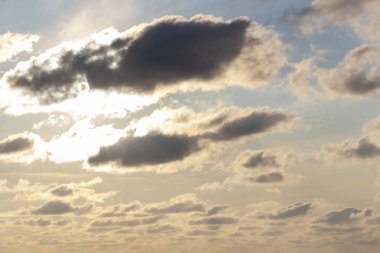 Gökyüzü mavi ve turuncu güneş ışığı gökyüzündeki bulutların arasından.