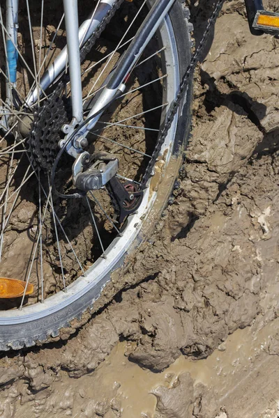 Bisiklet tekerleği çamura saplanmış. Kapat.