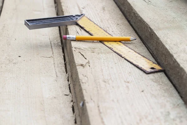 Kalem ve kirişüzerinde bir kare çizgi. Ahşap ev ve çatı inşaatı. — Stok fotoğraf
