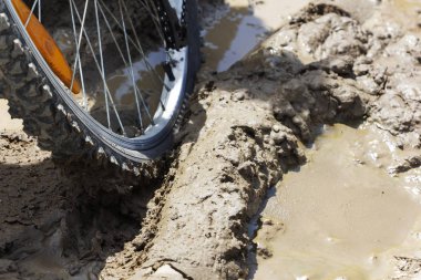 Bisiklet tekerleği çamura saplanmış. Kapat.