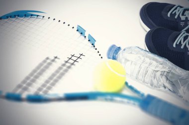 Beyaz arka planda tenis raketi. roket, top, su şişesi.