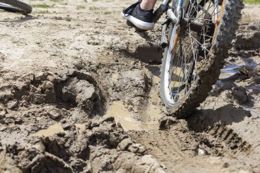 Bisiklet tekerleği çamura saplanmış. Kapat.