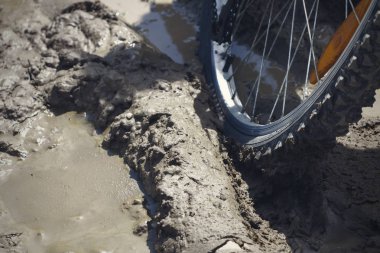 Bisiklet tekerleği çamura saplanmış. Kapat.