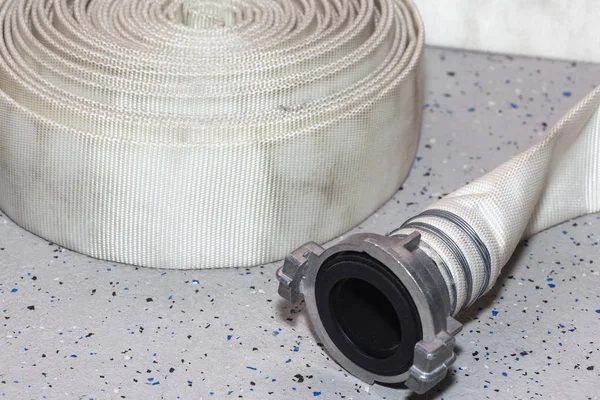 New fire hose, on the floor of the fire station. — Stock Photo, Image