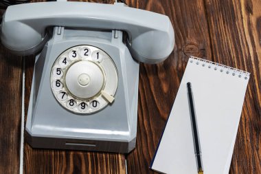Klasik gri telefon, tahta arka planda yazı tahtası yakın plan, üst görünüm.