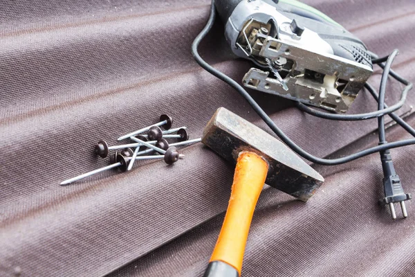 Close up view on asphalt roofing shingles background with hammer and nails. — Stock Photo, Image