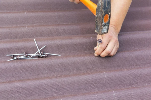 Roofer installs asphalt shingles Ondulin, roof repair.