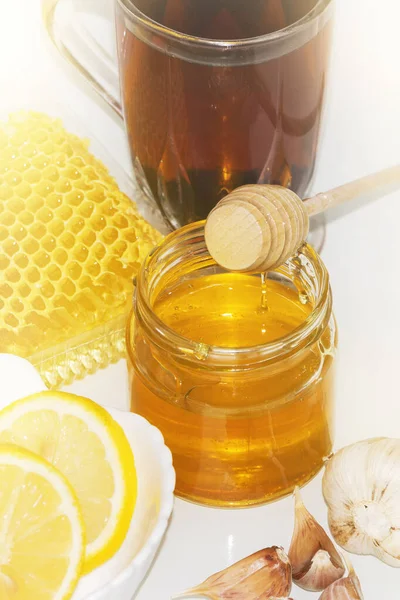 Honey on the background of honeycomb. Honey in a glass jar and honeycomb — Stock Photo, Image