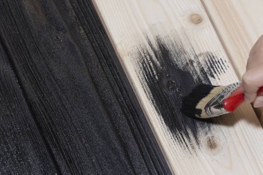 Tahta tahtayı siyaha boyamak. siyah boya ve fırça.