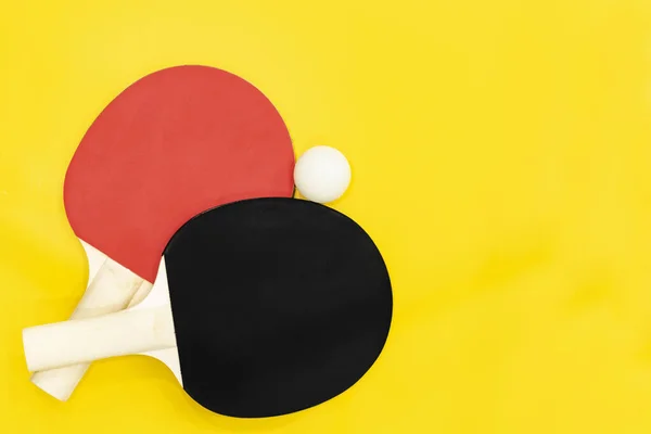Два настільні тенісні ракетки для пінг-понг на яскраво-жовтому тлі . Стокове Зображення