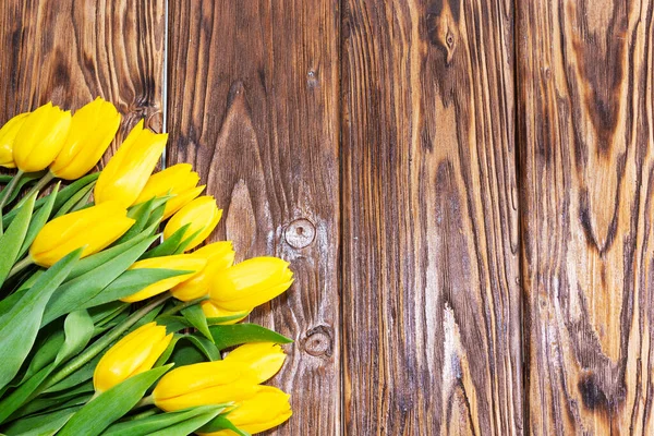 Den matek. tulipány květiny na tmavém dřevěném pozadí — Stock fotografie