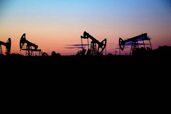 Platforma wiertnicza o zachodzie słońca, nocą, produkcja ropy naftowej na światowym rynku ropy naftowej — Zdjęcie stockowe
