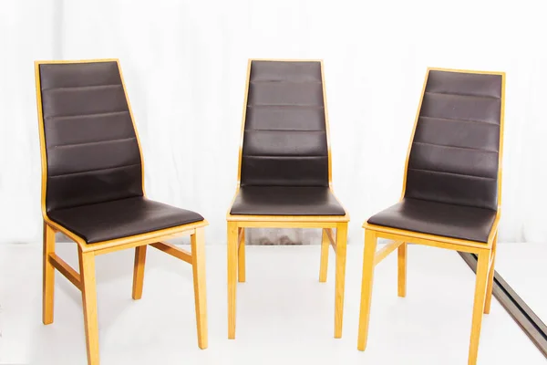Drei moderne neue Holzstühle mit Ledersitzen in der Werkstatt. — Stockfoto