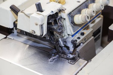 Dört iplikli endüstriyel dikiş makinesi. Üst kilit, bir veya iki parça kumaşın kenarı boyunca dikilen bir tür dikiştir..