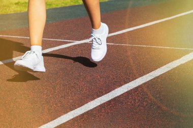 Bir koşucunun ayakları, ayakkabılarına yakın plan çekimde yol boyunca koşar. Koşu eğitimi, sağlıklı yaşam tarzı..