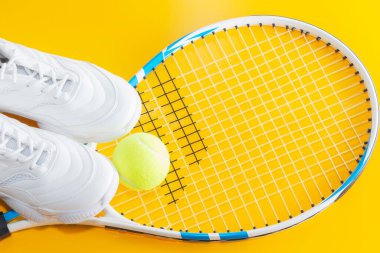 Toplu tenis raketi ve parlak bir arka planda spor ayakkabısı. Stüdyoda Fotoğraflandı.