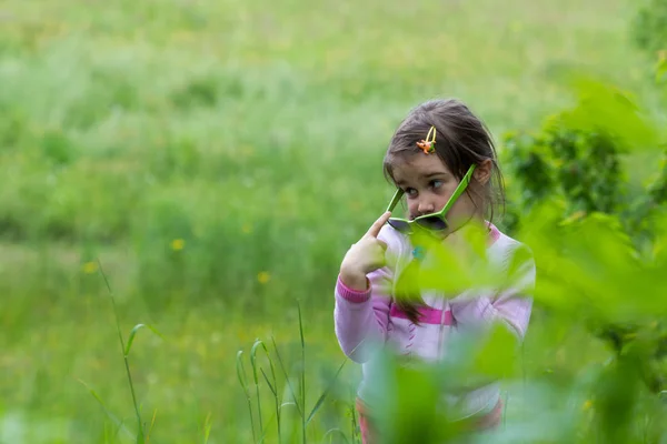 草の中にメガネをかけた女の子 春の時間 — ストック写真
