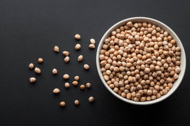 Kuru nohut izole koyu arka plan üzerinde beyaz kase. üstten görünüm