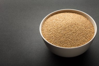 Seramik kase koyu arka plan üzerinde izole solmayan çiçek tohumları