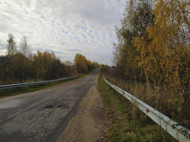Boş köy yolu, demiryolu çitleri, sonbahar bulutları