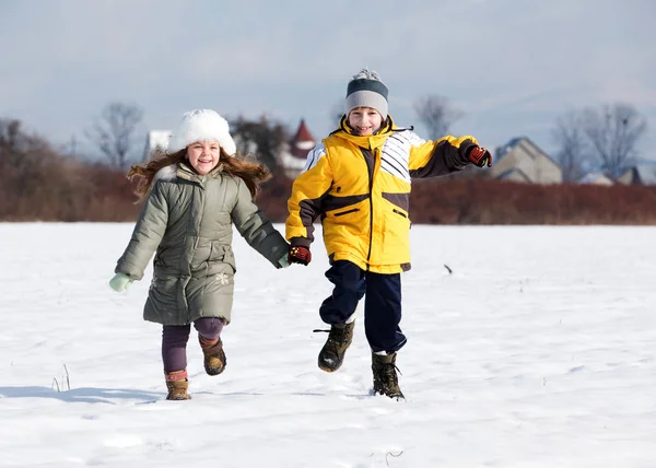 Due Bambini Che Corrono Sulla Neve Tenendosi Mano Sorridendo — Foto Stock