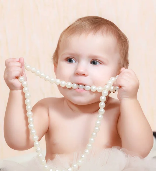肖像画の新生の赤ん坊真珠のネックレスのベッドで横になっています — ストック写真