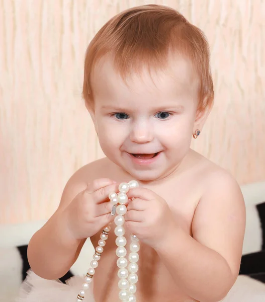肖像画の新生の赤ん坊真珠のネックレスのベッドで横になっています — ストック写真