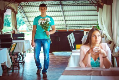 Onu adam için bekleyen kafede masada oturan genç kadın