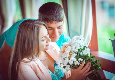 mutlu genç çift çiçekler Cafe ile portresi